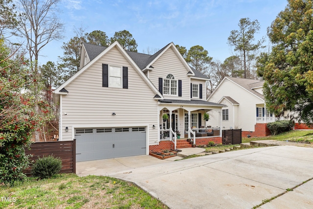 traditional-style home featuring covered porch, an attached garage, concrete driveway, and roof with shingles