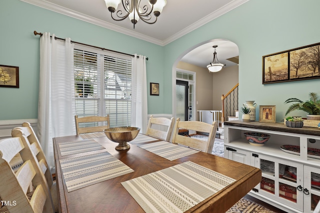 dining room featuring crown molding, a chandelier, stairway, wood finished floors, and arched walkways