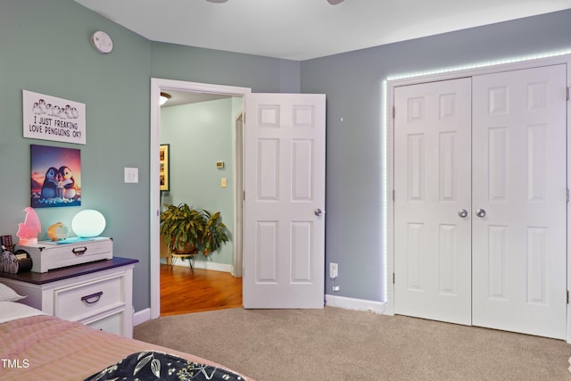 carpeted bedroom featuring a closet and baseboards