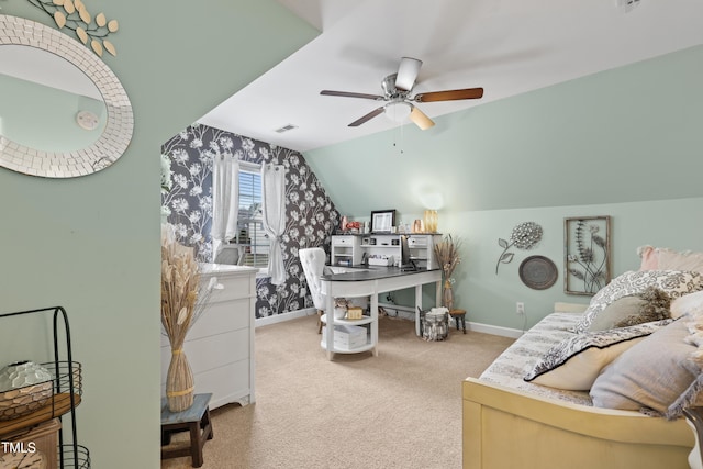 carpeted home office featuring visible vents, lofted ceiling, baseboards, and ceiling fan