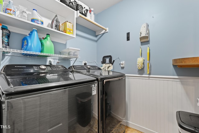 washroom with laundry area, a wainscoted wall, and washing machine and clothes dryer