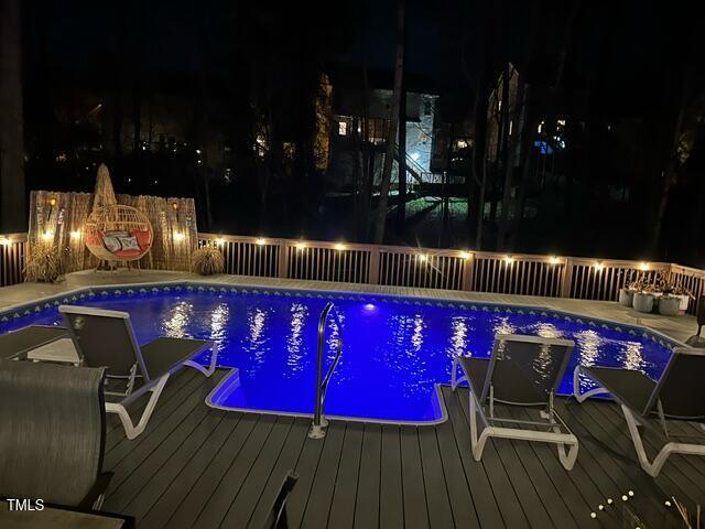 view of pool with a fenced in pool, a deck, and fence