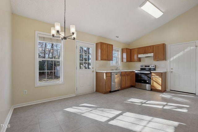 kitchen featuring under cabinet range hood, a sink, light countertops, appliances with stainless steel finishes, and brown cabinetry