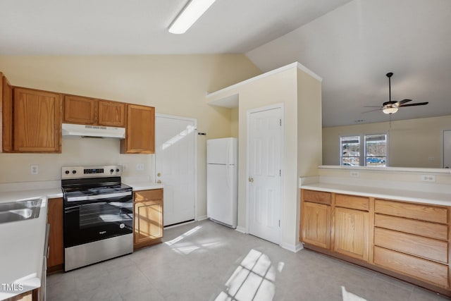 kitchen featuring light countertops, freestanding refrigerator, stainless steel range with electric cooktop, vaulted ceiling, and under cabinet range hood