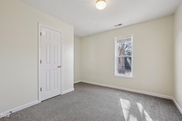 unfurnished bedroom featuring carpet, a textured ceiling, visible vents, and baseboards