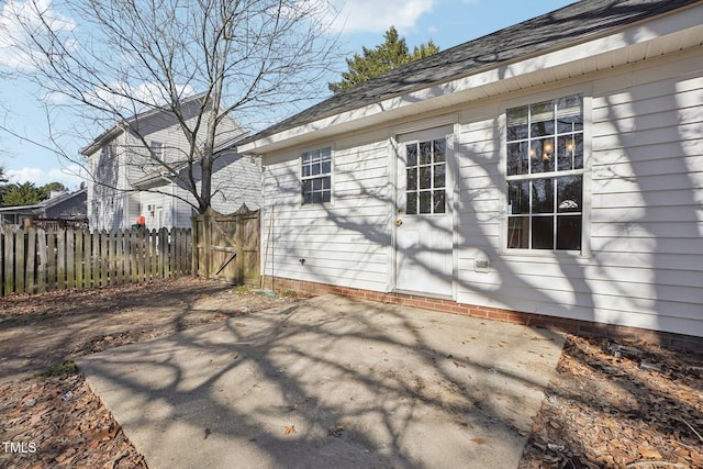 view of property exterior with crawl space, roof with shingles, fence, and a patio