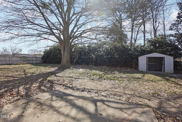 view of yard featuring a shed, fence, and an outbuilding