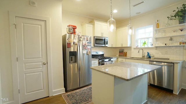 kitchen with light stone counters, stainless steel appliances, a sink, visible vents, and dark wood-style floors