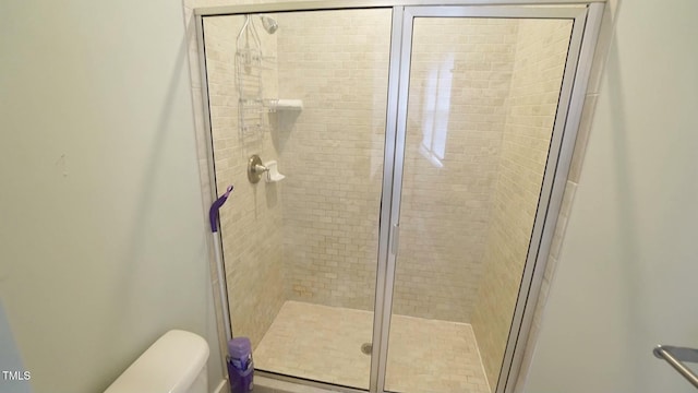 bathroom with a shower stall and toilet