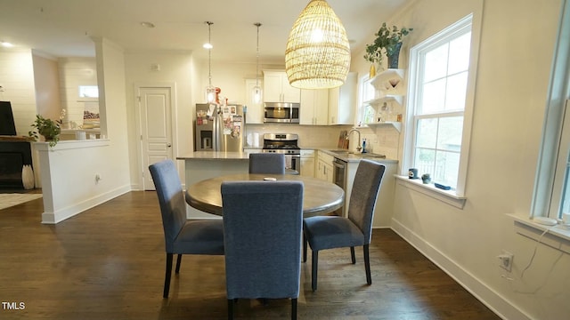 dining area with baseboards, a chandelier, dark wood-style flooring, and ornamental molding