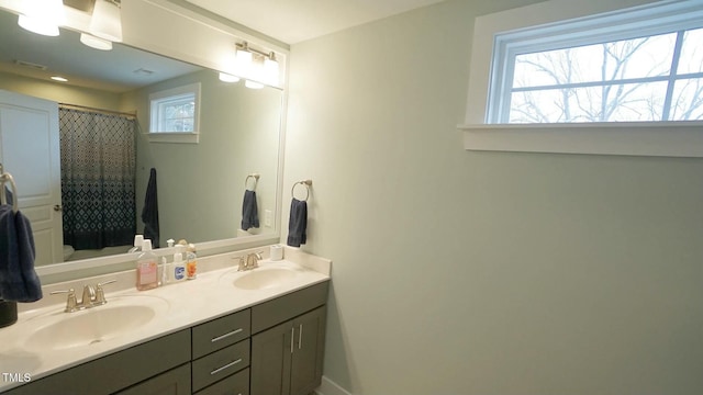 full bath featuring double vanity, a shower with shower curtain, a sink, and toilet