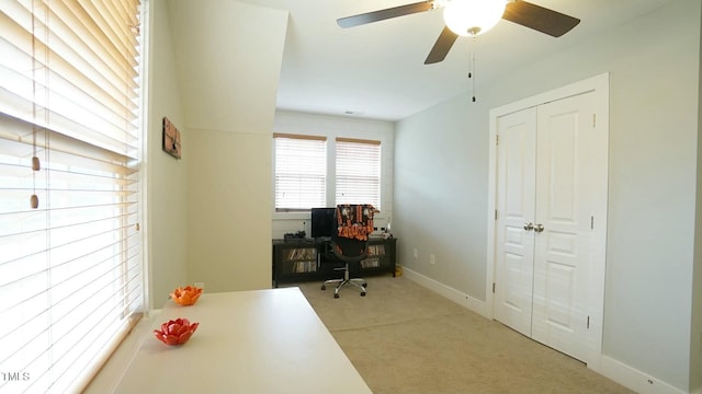 office space with ceiling fan and baseboards