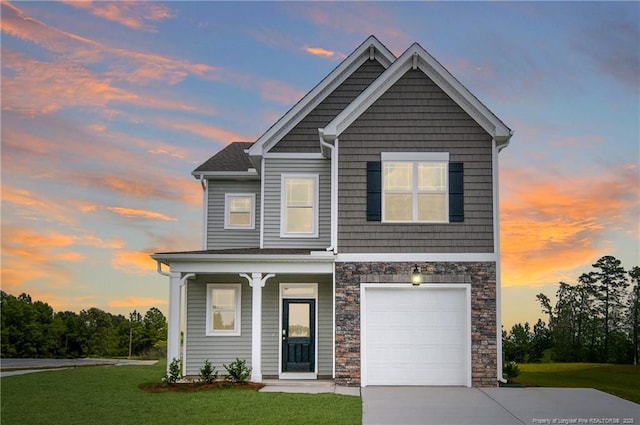 view of front of house featuring an attached garage, covered porch, stone siding, driveway, and a front lawn