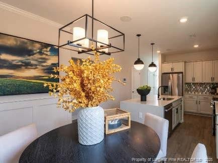 dining area with dark wood-style floors, ornamental molding, and recessed lighting