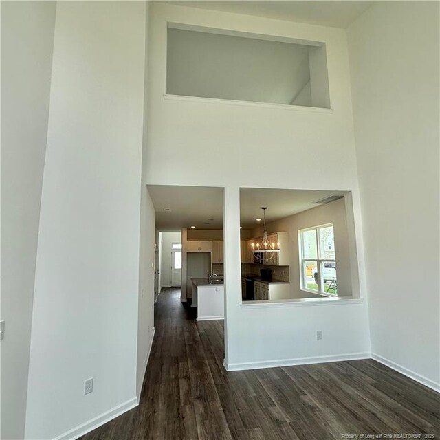 659 Union St, Home, Raeford, NC 28376 - kitchen with a chandelier, dark wood-type flooring, a high ceiling, and white cabinetry