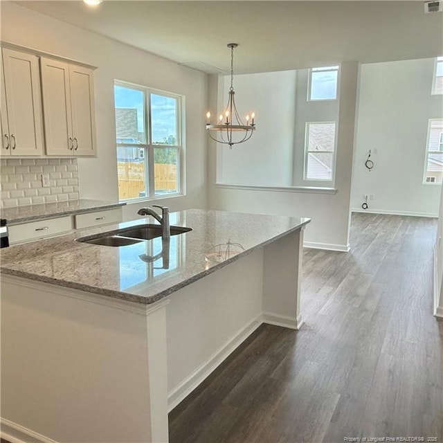 659 Union St, Home, Raeford, NC 28376 - kitchen featuring light stone counters, dark wood-style floors, white cabinetry, a kitchen island with sink, and decorative light fixtures