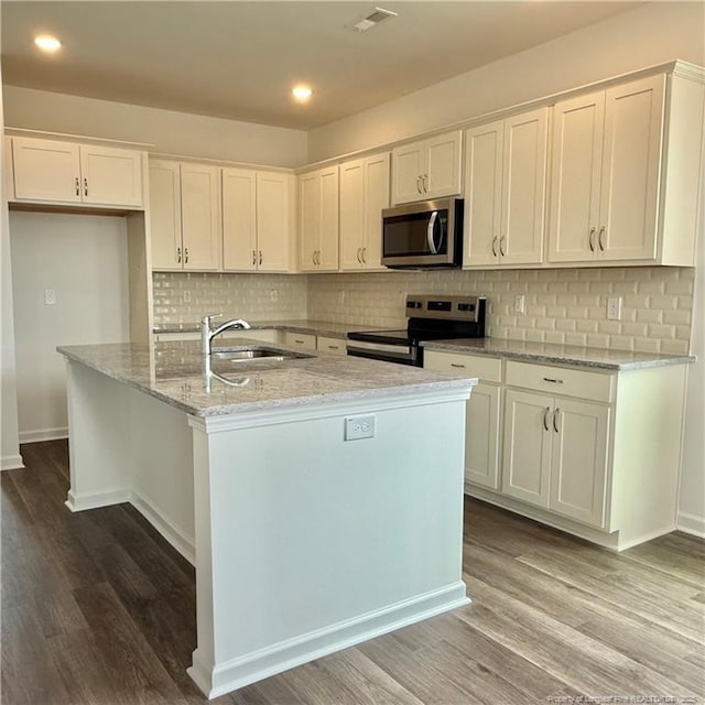 659 Union St, Home, Raeford, NC 28376 - kitchen with appliances with stainless steel finishes, white cabinetry, wood finished floors, a center island with sink, and recessed lighting