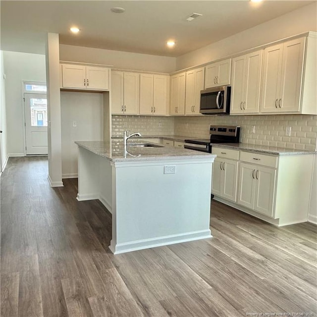 659 Union St, Home, Raeford, NC 28376 - kitchen with stainless steel appliances, wood finished floors, white cabinetry, backsplash, and recessed lighting