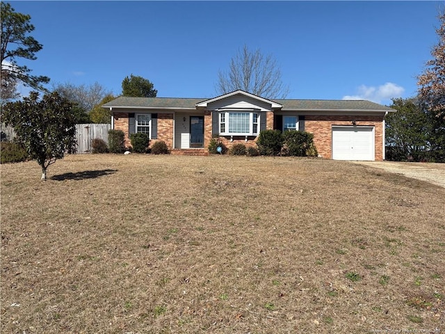 ranch-style house featuring an attached garage, brick siding, fence, driveway, and a front lawn