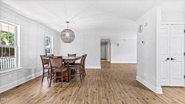 dining room with ornamental molding, wood finished floors, visible vents, and baseboards