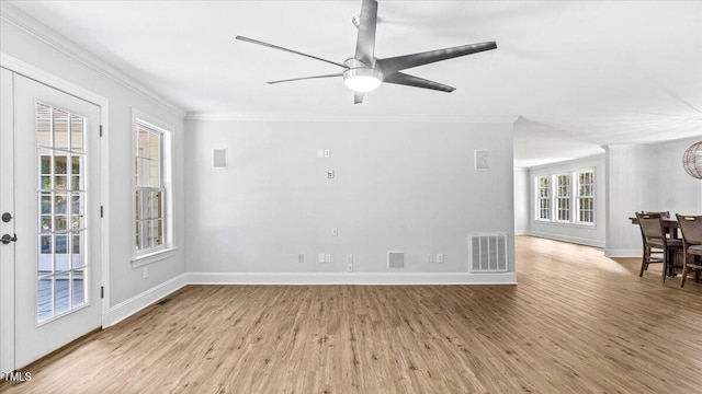 spare room featuring ornamental molding, visible vents, baseboards, and wood finished floors