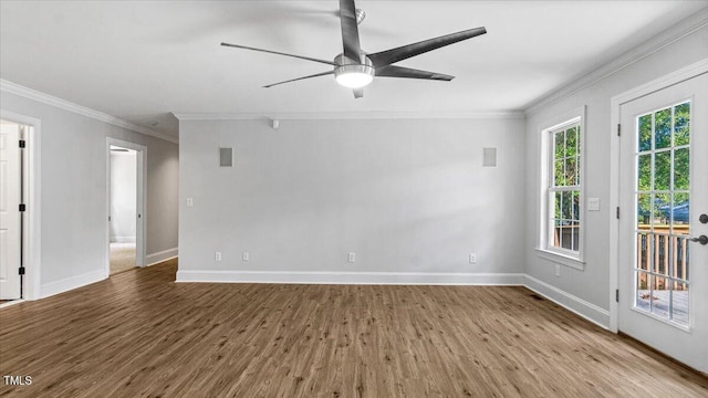 empty room featuring ceiling fan, crown molding, baseboards, and wood finished floors