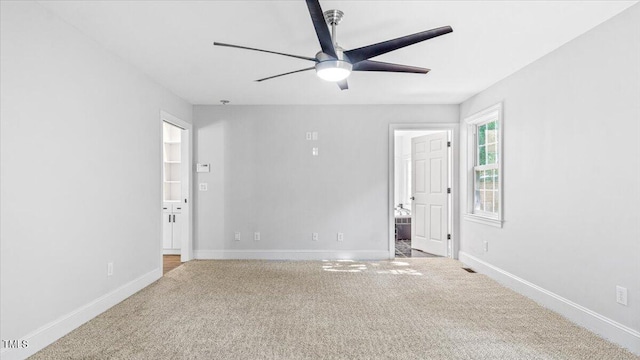 unfurnished room featuring carpet floors, ceiling fan, and baseboards