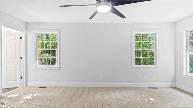 carpeted empty room with plenty of natural light, visible vents, and baseboards