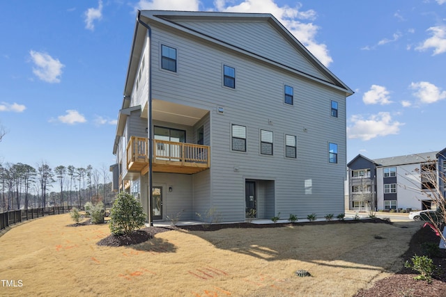 back of property with fence and a balcony