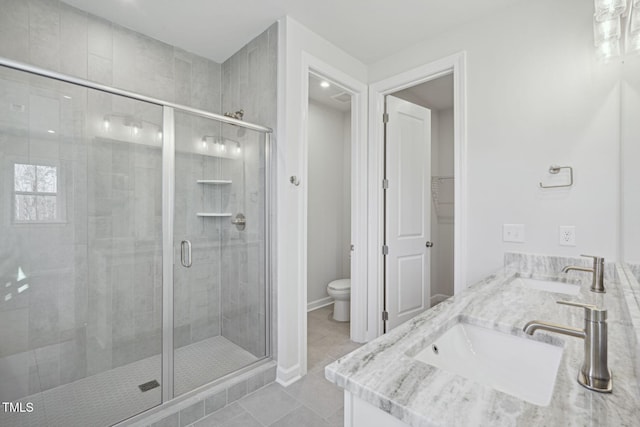 bathroom featuring tile patterned flooring, a sink, a shower stall, and toilet