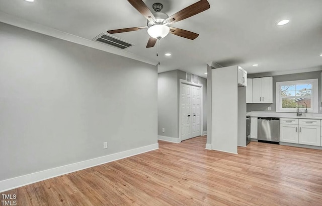 unfurnished living room featuring a sink, light wood-style flooring, visible vents, and baseboards