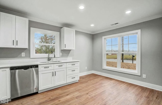 kitchen featuring baseboards, visible vents, dishwasher, light countertops, and a sink