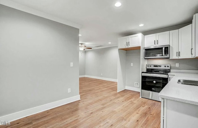 kitchen featuring recessed lighting, appliances with stainless steel finishes, a ceiling fan, white cabinetry, and light wood-type flooring