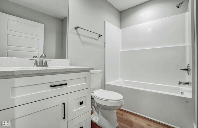 full bath with shower / bath combination, vanity, toilet, and wood finished floors