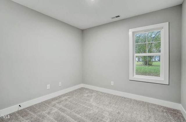 carpeted empty room with visible vents and baseboards