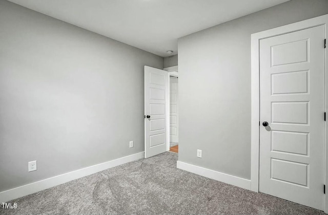 unfurnished bedroom featuring carpet and baseboards