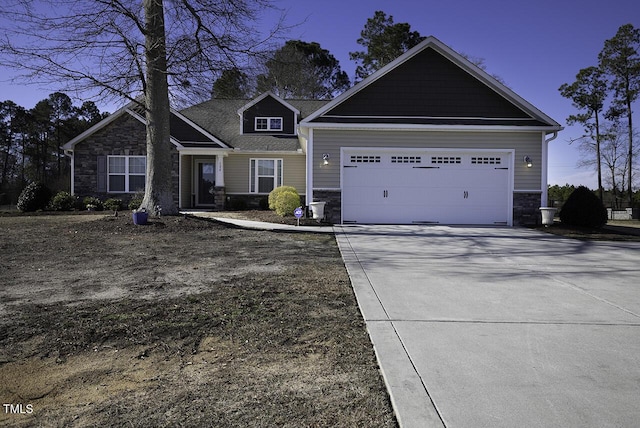 craftsman inspired home featuring stone siding, an attached garage, and driveway