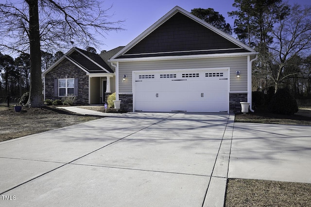 craftsman house featuring driveway, stone siding, and a garage