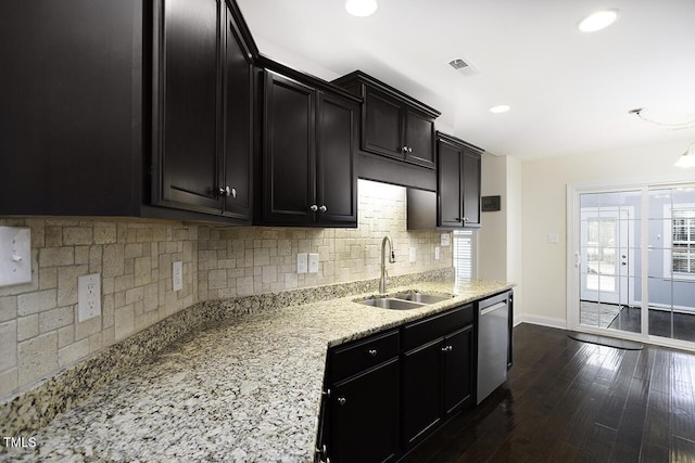 kitchen featuring dark wood-style flooring, visible vents, stainless steel dishwasher, a sink, and dark cabinets