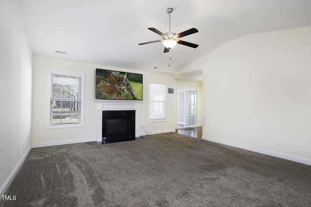 unfurnished living room featuring a fireplace with flush hearth, lofted ceiling, visible vents, and plenty of natural light