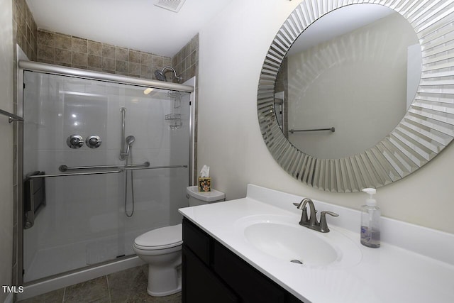 bathroom with visible vents, toilet, a shower stall, vanity, and tile patterned floors