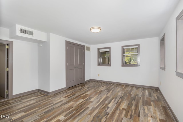 unfurnished room with baseboards, visible vents, and wood finished floors