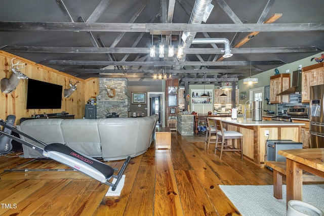 interior space with dark wood finished floors, beamed ceiling, and a stone fireplace