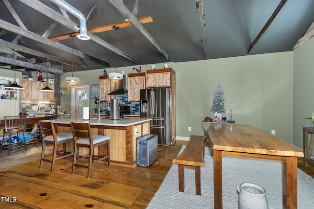 kitchen with tasteful backsplash, dark wood-style flooring, light countertops, and stainless steel fridge with ice dispenser