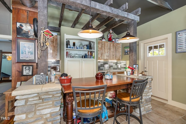 dining area featuring tile patterned flooring and beam ceiling