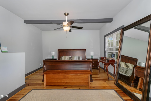 bedroom featuring light wood-style floors, beam ceiling, ceiling fan, and baseboards