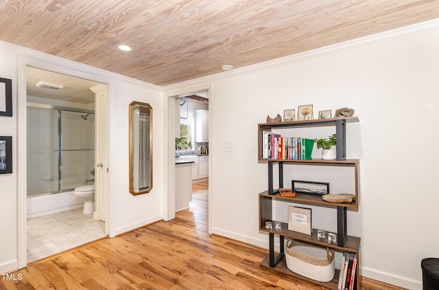 hall featuring ornamental molding, wood ceiling, light wood-style flooring, and baseboards