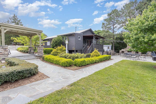 exterior space featuring a patio area, fence, and a front lawn