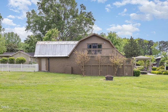 exterior space featuring stairway, a yard, fence, and a gambrel roof