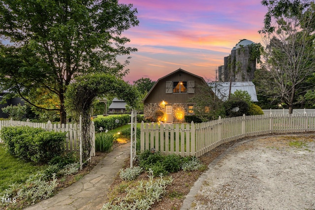 view of home's exterior featuring a fenced front yard and a gambrel roof